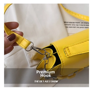 Close-up of durable silver metal swivel hook and stitching on yellow crossbody bag