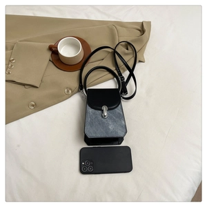 Mini trapezoid crossbody bag in black leather and denim patchwork on white bedding
