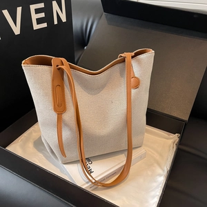 Large capacity canvas tote bag with brown leather handles in minimalist trapezoid style