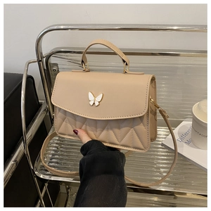 Makroaufnahme der beigen PU-Ledertasche mit Schmetterlings-Metallschließe und V-Steppnaht