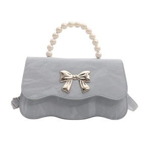 Light blue crossbody bag with pearl handle and silver bow detail on scalloped edge