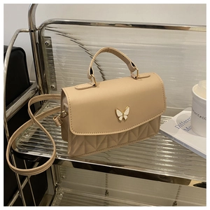 Detail der beige gesteppten Umhängetasche mit Schmetterlings-Metallverschluss