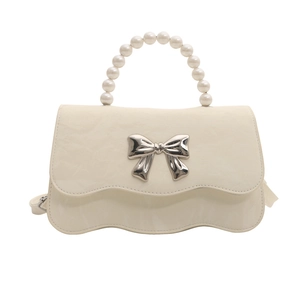 Cream bow accent crossbody bag with pearl handle and wave-edge flap design