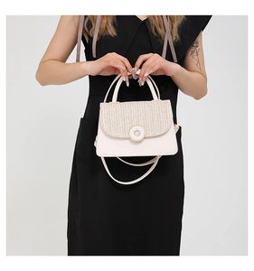 Close-up of contrast woven texture and golden ring buckle on beige crossbody square bag