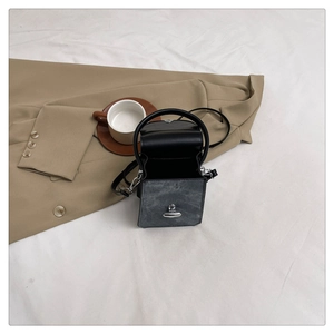 Top-down view of a stylish black and grey square handbag with silver metal lock closure
