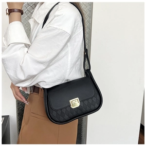 Detail of black quilted leather shoulder bag featuring a gold rectangle metal push lock