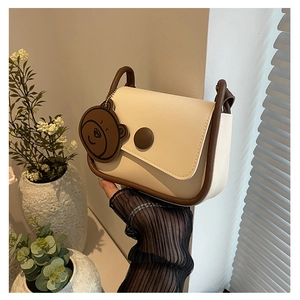 Détail du sac besace crème et marron avec un charme d'ours mignon en décor de style