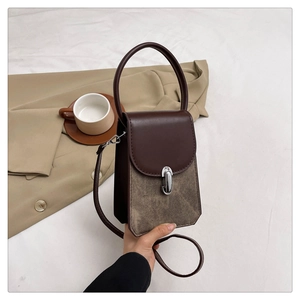 Detail of vintage tote bag with brown leather flap, khaki suede body, and metal buckle