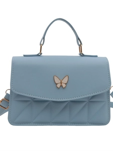 Light blue quilted crossbody bag with white butterfly detail and adjustable strap