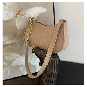 Detail of camel retro shoulder bag with V-shaped quilting and golden chain accents