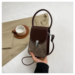 Detail of retro small square bag showing contrasting leather textures and silver buckle