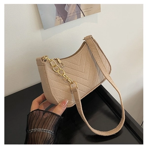 Detail of camel quilted shoulder bag with gold chain strap and textured fabric