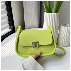 Detail of neon green leather mini crossbody bag with gold square lock and quilted texture