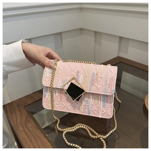 Close-up of pink crossbody bag featuring colorful embroidery and golden chain strap