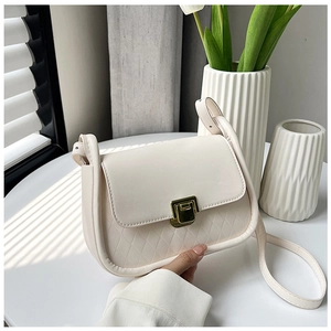 Detail of cream white leather bag with golden square lock and quilted texture pattern