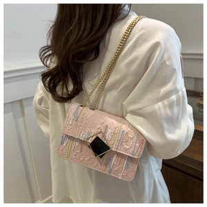 Detail of pink crossbody bag with colorful embroidery and gold-tone chain strap