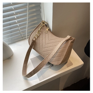 Detail of beige textured fabric shoulder bag with V-shaped stitching and gold chain