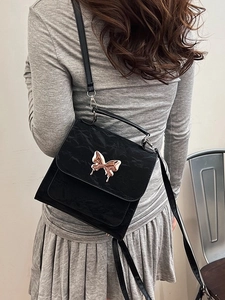 Elegant black wrinkled patent leather crossbody bag with liquid gold butterfly buckle