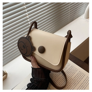 Détails du sac de selle minimaliste avec garniture contrastée et charm ours mignon