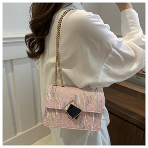 Detail of pink chain crossbody bag with colorful embroidery and geometric metal clasp