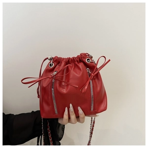 Close-up of red leather bucket backpack featuring silver zippers and drawstring closure