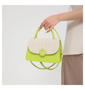 Detail of crossbody bag featuring woven texture flap and lime green contrast buckle