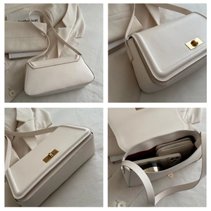 Detail view of beige crossbody bag showing golden twist lock and spacious interior