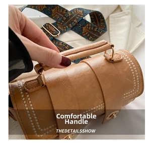 Detail of caramel cylinder handbag with vintage patterned strap and wave stitching