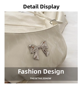 Macro shot of white pleated handbag detail featuring a silver metallic bow decoration
