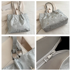 Detailed views of silver tote bag featuring swallow metal charms and zip closure details