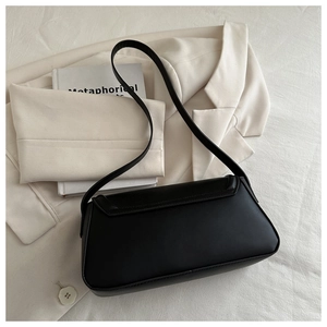 Classic black underarm bag with smooth matte finish and long strap on white background