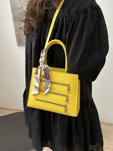 Chic yellow square crossbody bag with decorative zippers and elegant silk scarf