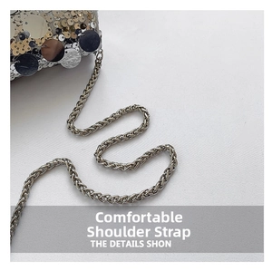 Macro detail of sparkly metal sequins and twisted silver chain strap on a fashion bag