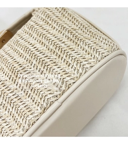 Detailed macro view of woven straw texture with white leather trim and fine stitching