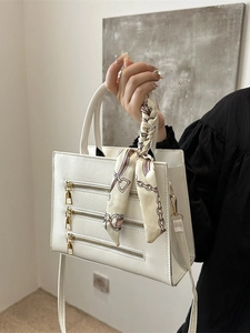 Minimalist white PU leather handbag with decorative gold zippers and elegant silk scarf
