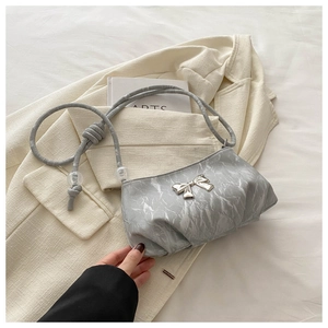 Detail of grey marble textured handbag with silver bow and beaded shoulder strap