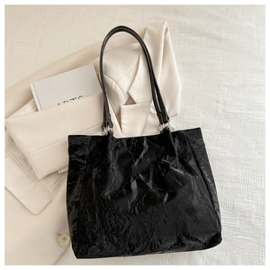 Detailed top view of a black pleated textured bucket bag with silver metal ring straps
