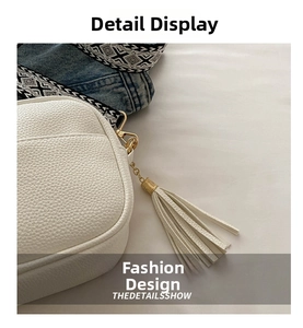 Close-up of white pebble leather handbag with woven strap and tassel detail