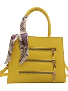 Bright yellow tote bag with three decorative zippers and a floral scarf handle wrap
