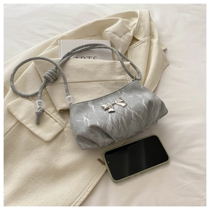 Detail of grey marble texture shoulder bag with silver bow and beaded knot strap