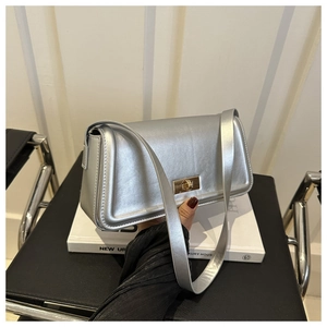 Detail of silver metallic leather handbag with gold twist lock and shoulder strap