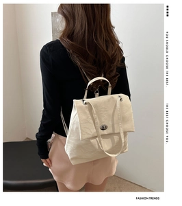 Detail of off-white backpack showing silver twist lock and unique pleated texture