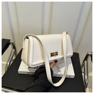 Close-up of the white leather shoulder bag with a polished gold metal twist lock