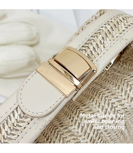 Close-up of golden metal clasp on beige woven straw handbag with leather trim