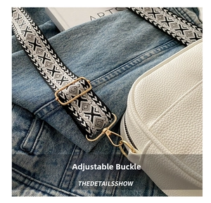 Adjustable woven shoulder strap in ethnic pattern with gold metal hardware on leather bag