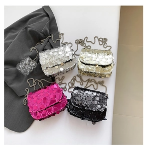 Flat lay of sequined chain bags in silver, gold, rose red, and black on a table