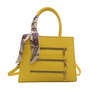 Bright yellow fashionable trapezoid handbag with triple gold zippers and silk scarf handle
