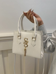 White leather square handbag with golden S logo and tassel fringe in a modern style
