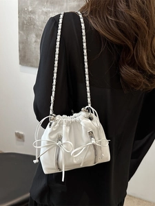 Fashionable white leather bucket backpack for women with chain strap and bow details