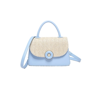 Light blue crossbody bag with woven straw flap and circular buckle accent